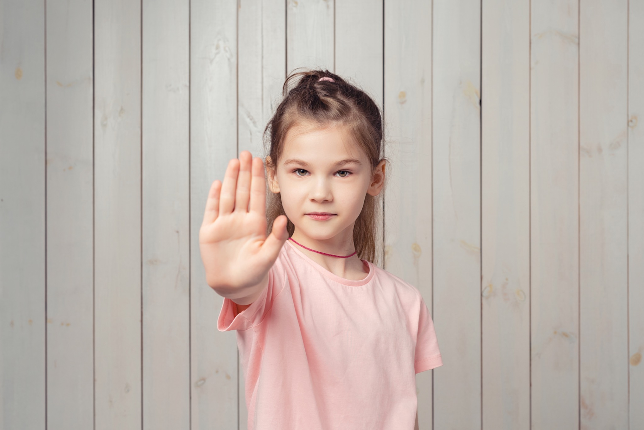 Kind zeigt mit ausgestreckter Hand eine klare Stopp-Geste